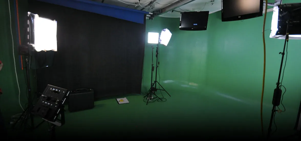A photo of a green room studio with lights, screens, and a black backdrop.